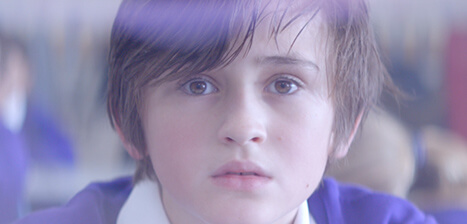 Boy in a purple top looking to camera