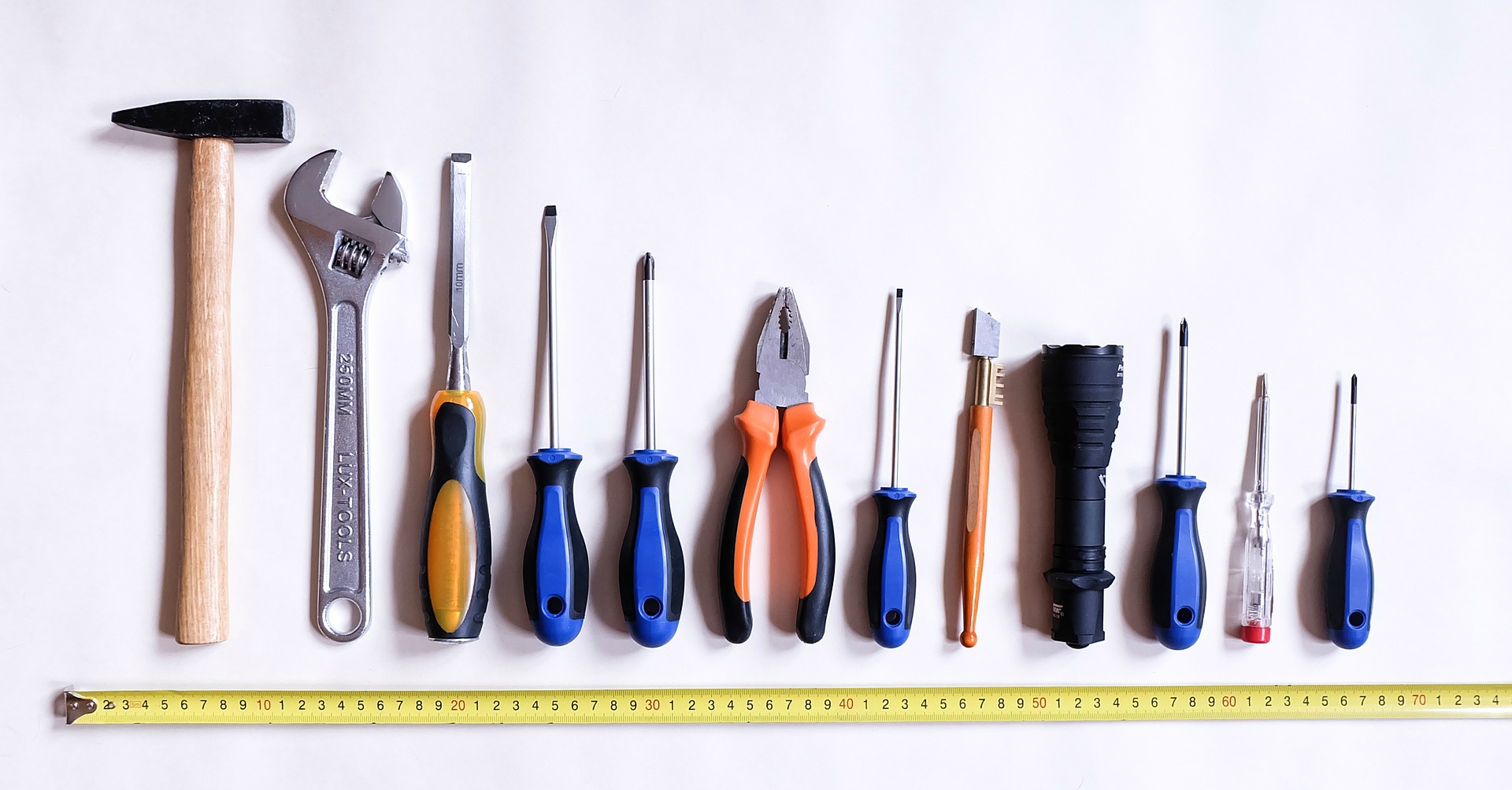 Measuring tape with a group of tools laid out from largest to smallest