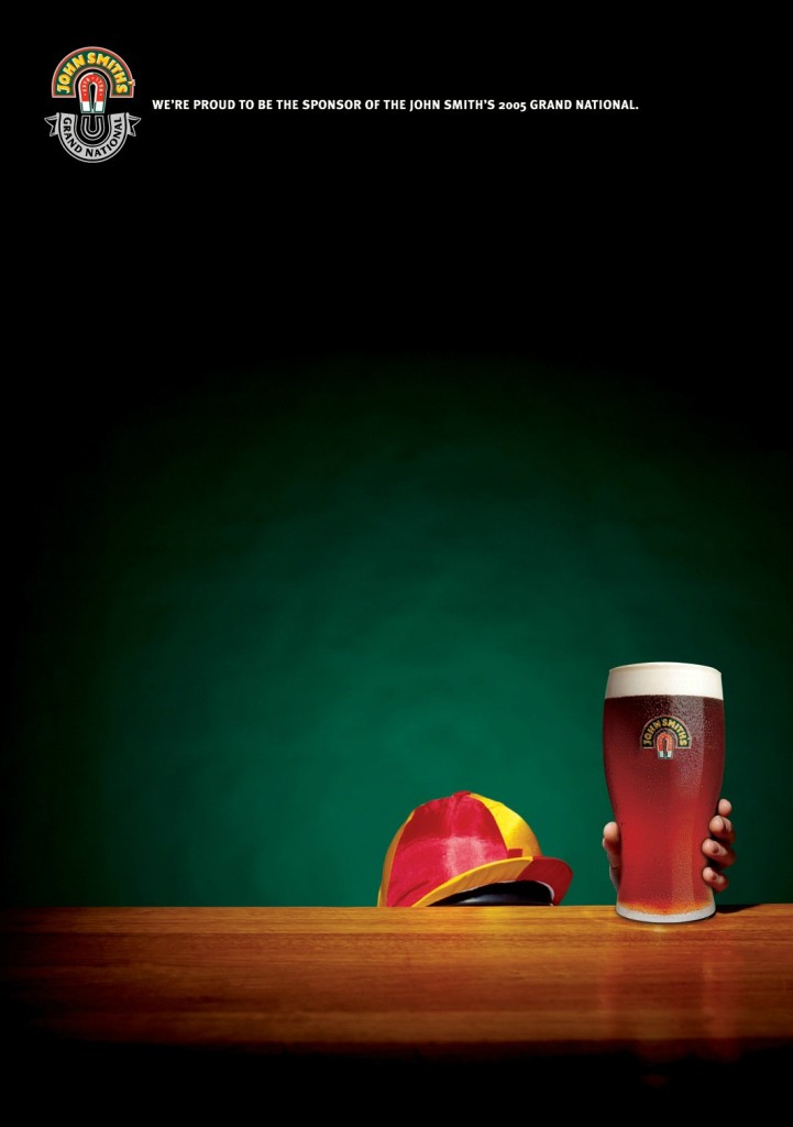 campaign ad with Small Jockey reaching up behind a bar for a pint of John Smith's, only seeing the red and yellow striped hat of the Jockey