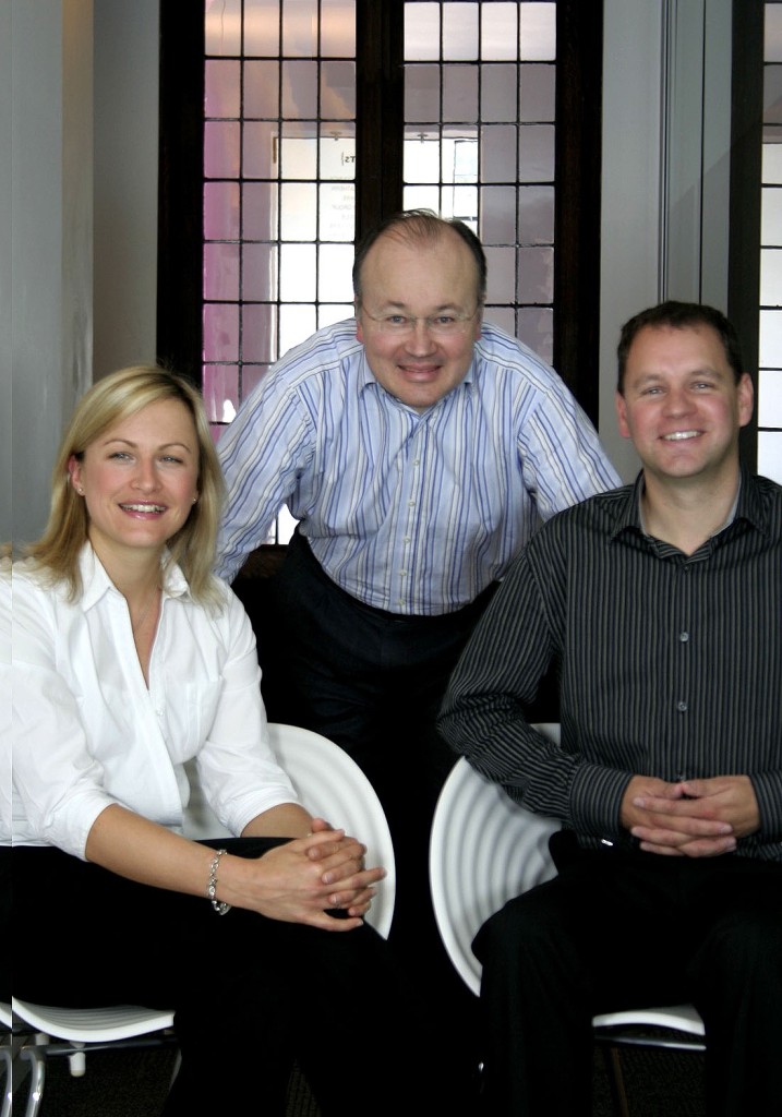 Three people looking at the camera, two men and one woman