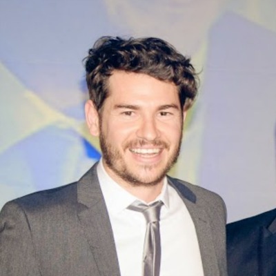 Euan Auld, man in grey suit smiling and looking at camera