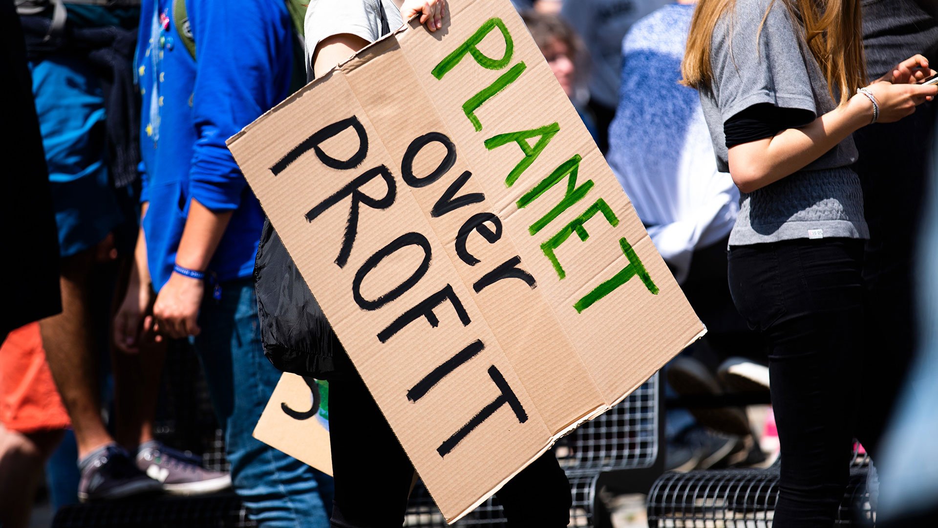 Protesters with sign "Planet over profit"