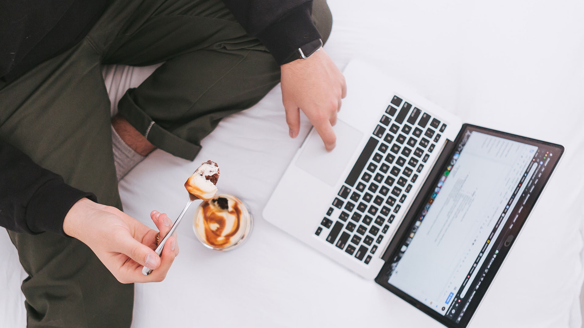 Man on floor using laptop and eating