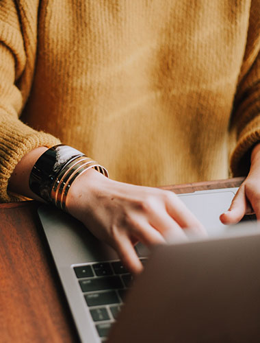 Person in yellow top using a laptop