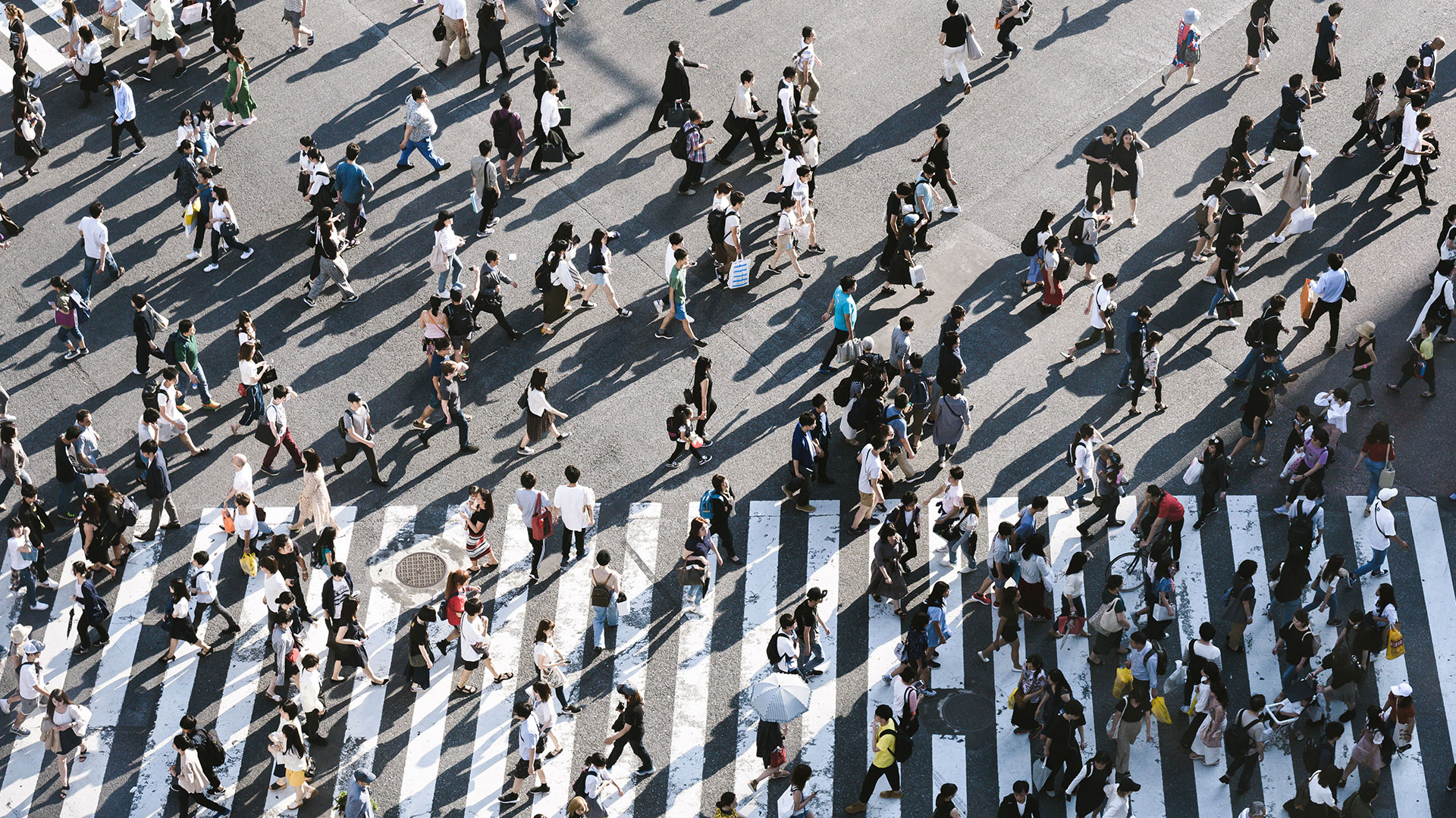 Overhead shot of road crossing and masses of people crossing the road