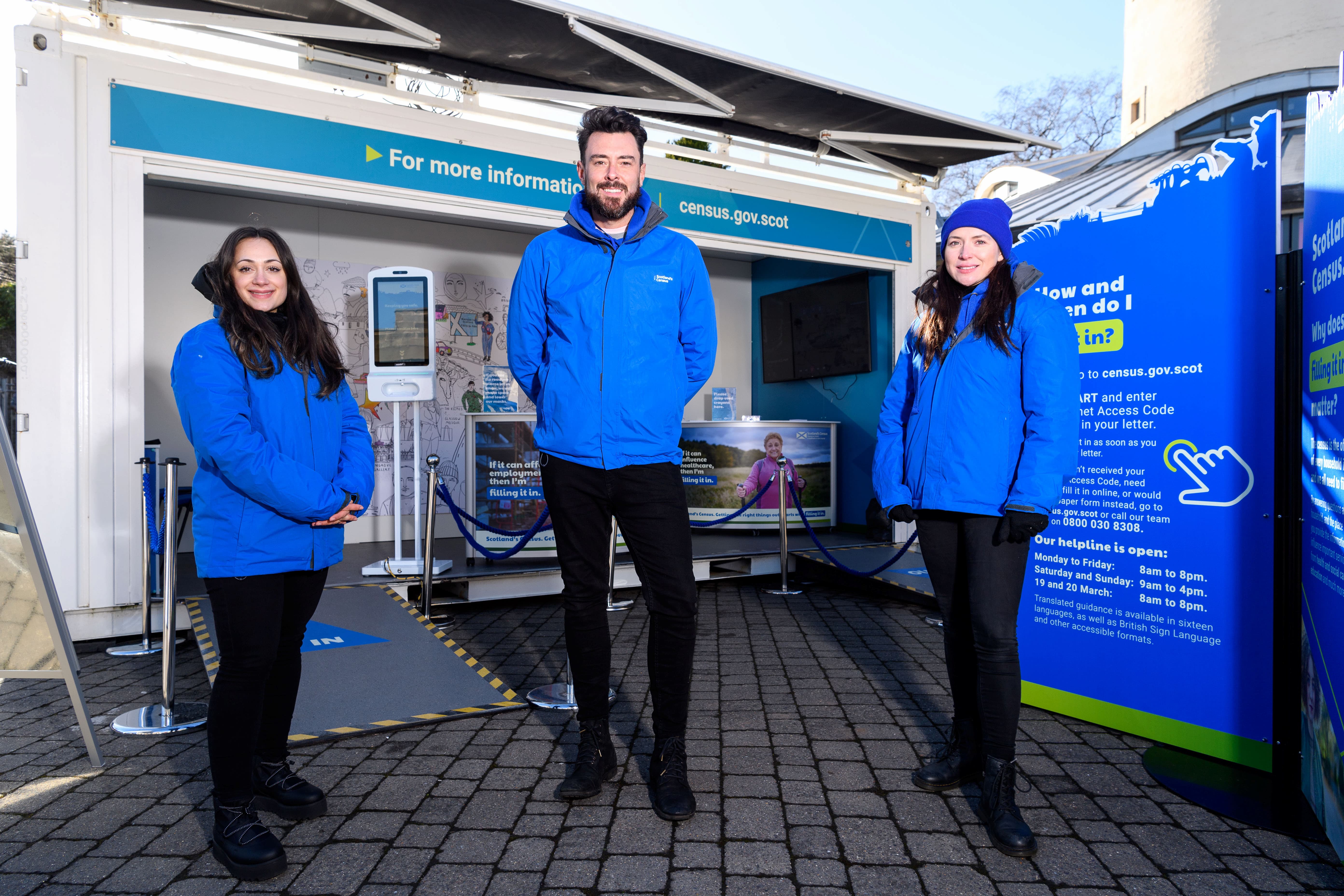 Group of people in front of display stands and unit