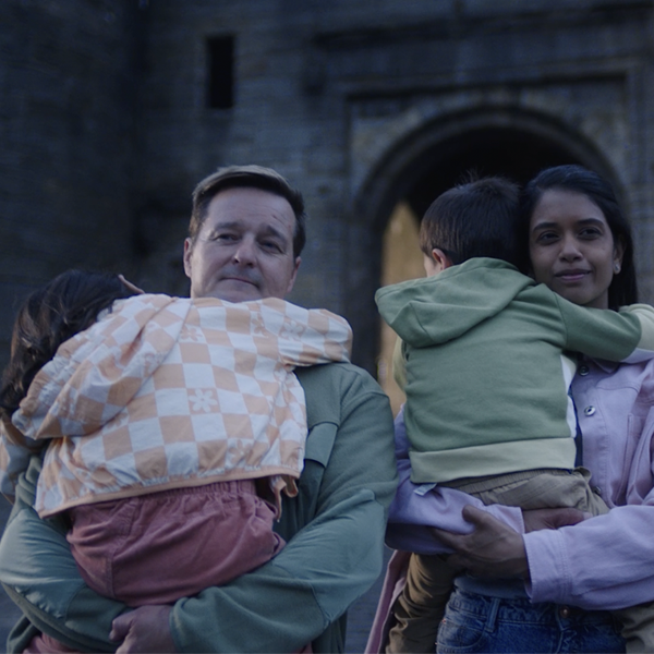 Family, man and woman carrying children who are sleeping