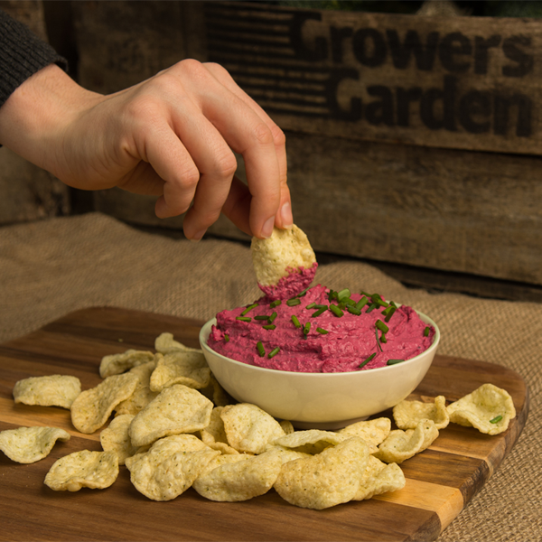 person dipping crisp into bowl of salsa 