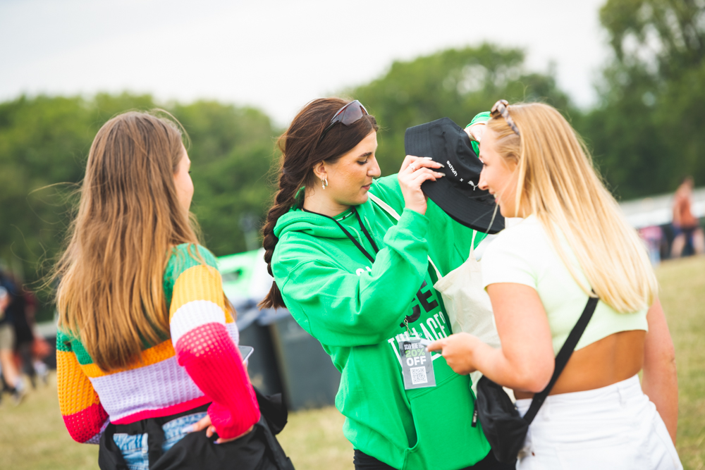 people speaking to person in green hoodie