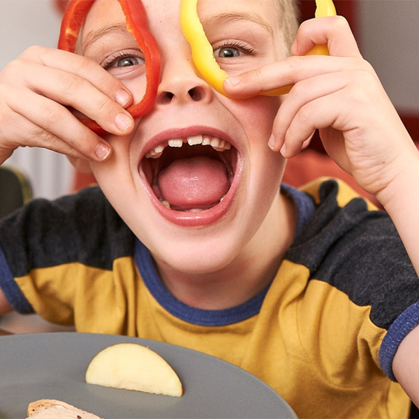 Child laughing and playing with food