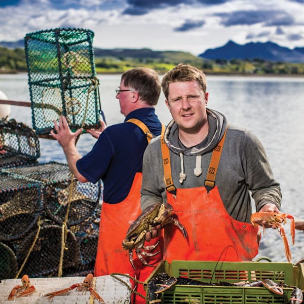 Two men at a dock working with fresh catches from the sea