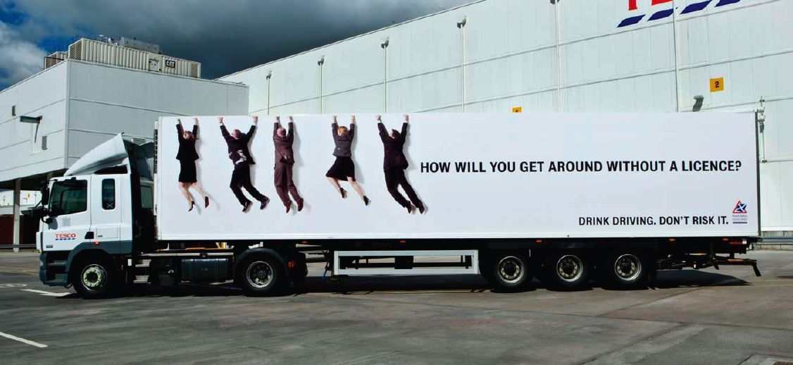 Lorry leaving depot with people hanging off the side ad campaign