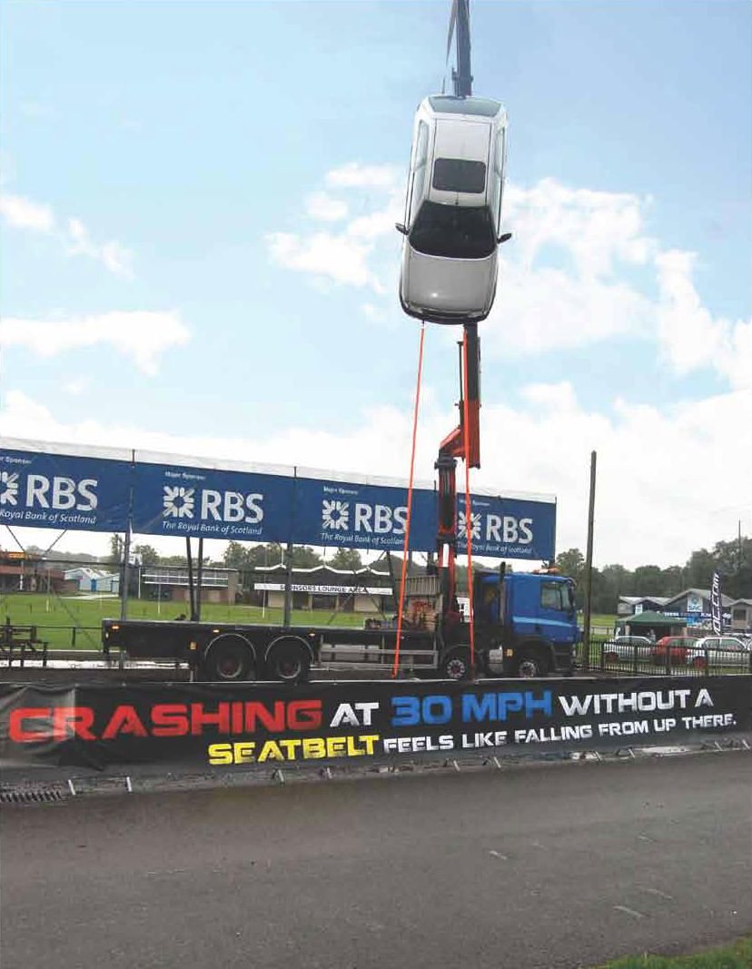 Car hanging from a crane up side down ad campaign