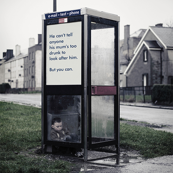 small boy sleeping in phone box