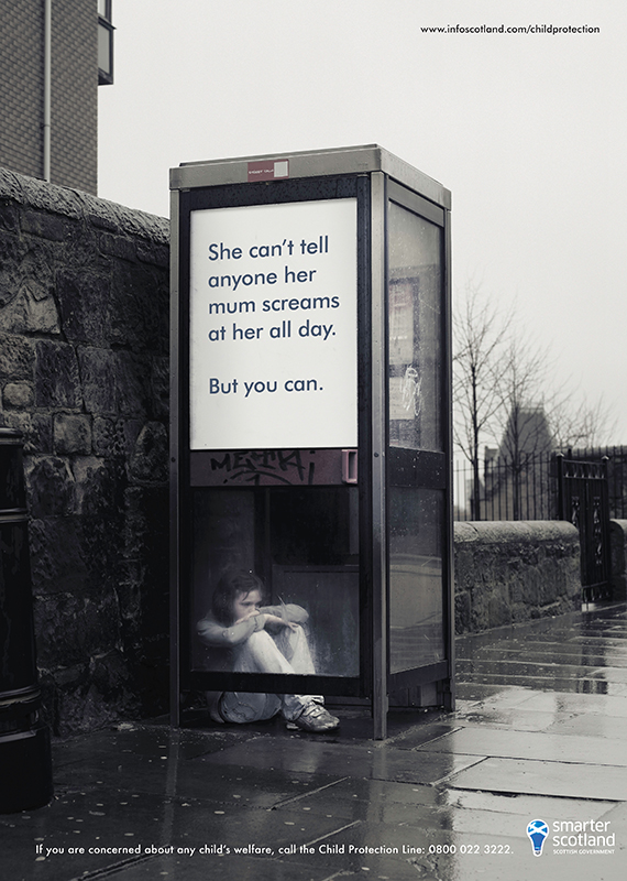 small child huddled in phone box