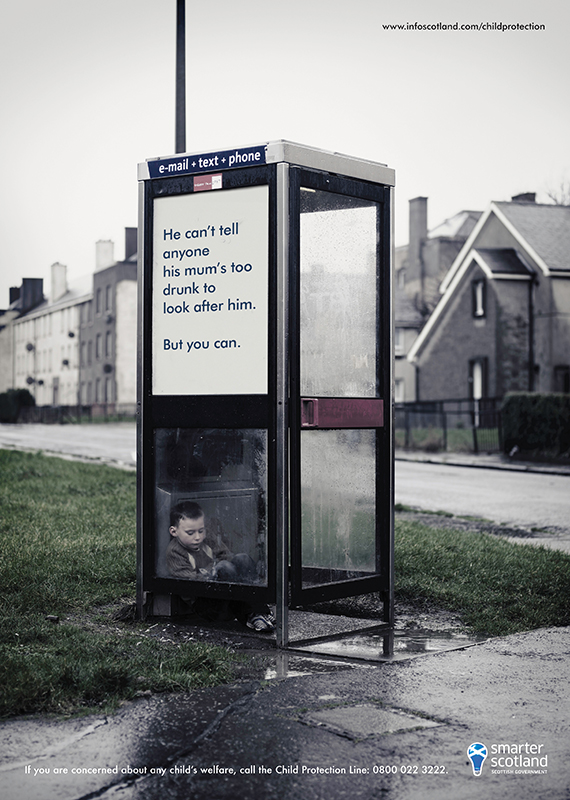 small child huddled in phone box