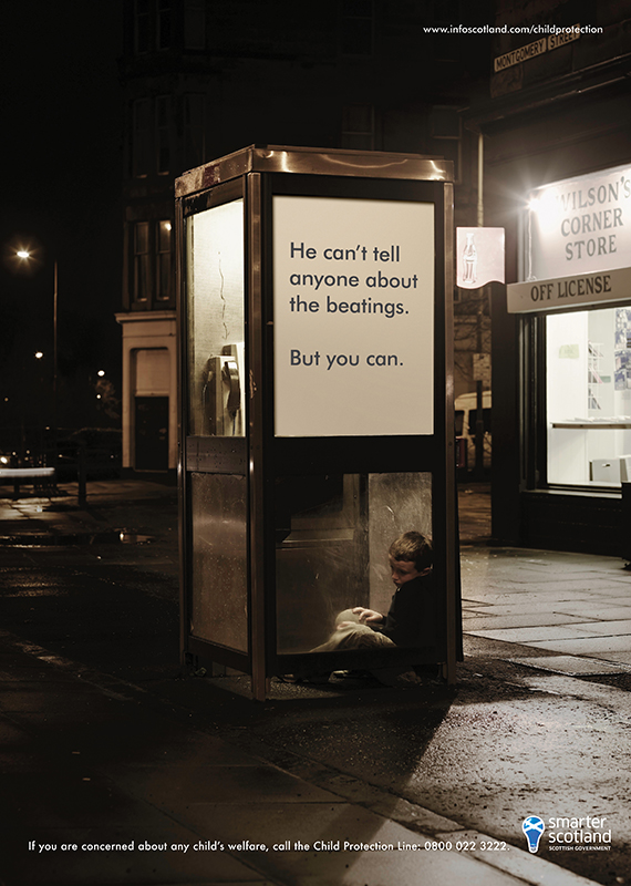 small child huddled in phone box