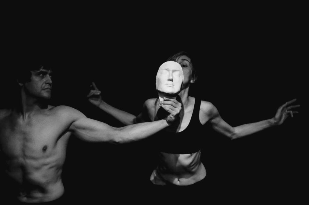 dancers, man holding mask up to woman's face