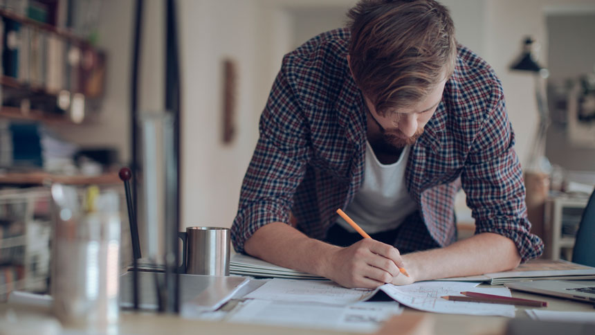 man working at table, drafting a document