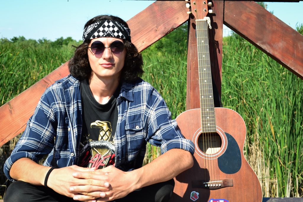 Man sitting next to a guitar 