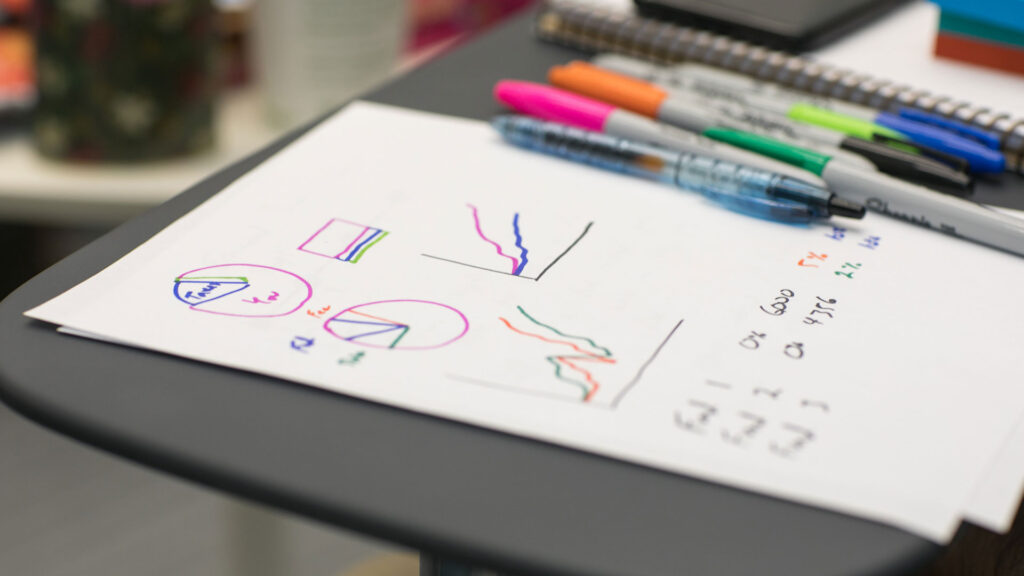 paper and coloured pens at desk