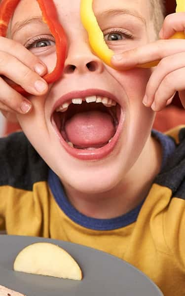 Child laughing and playing with food