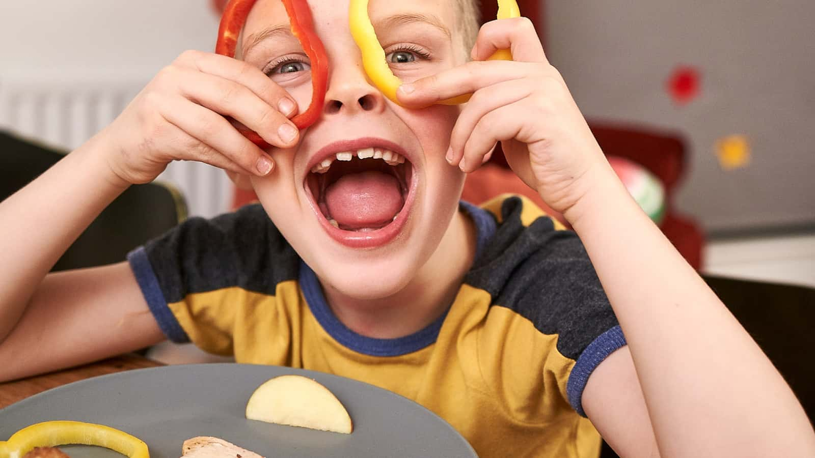 Child laughing and playing with food