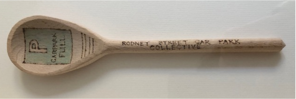 wooden spoon with drawing and text written on it