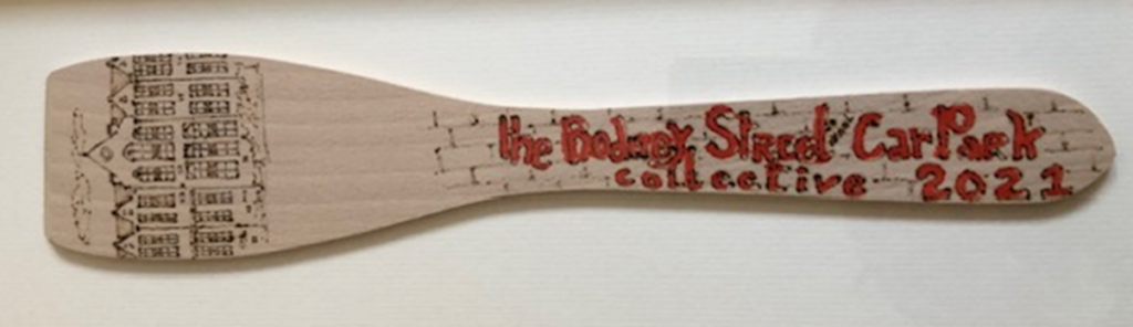 Woden spoon with drawings and text written on it