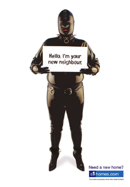 Man in Gimp suit holding up sign