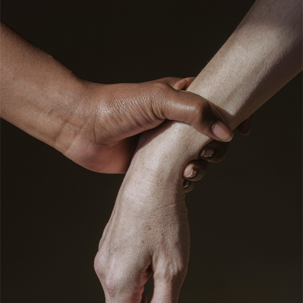 Hand griping wrist of and another person's arm