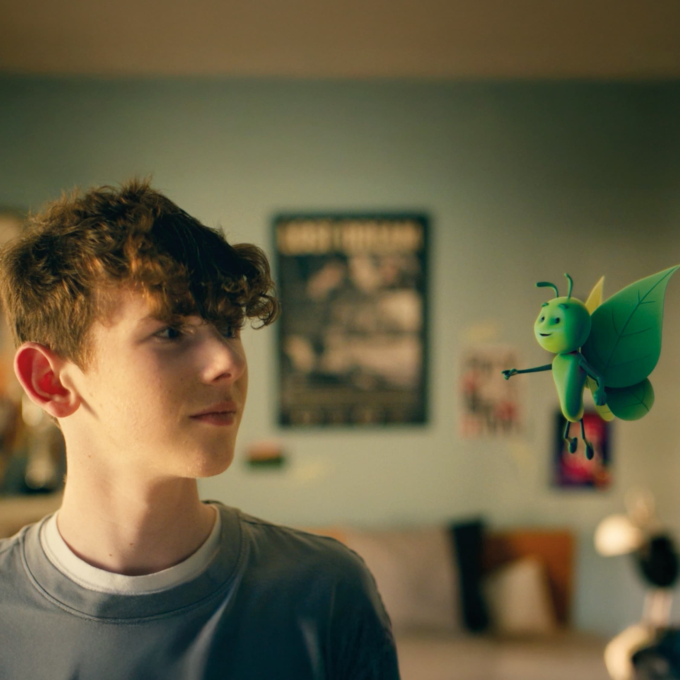 Boy looking at flying green bug